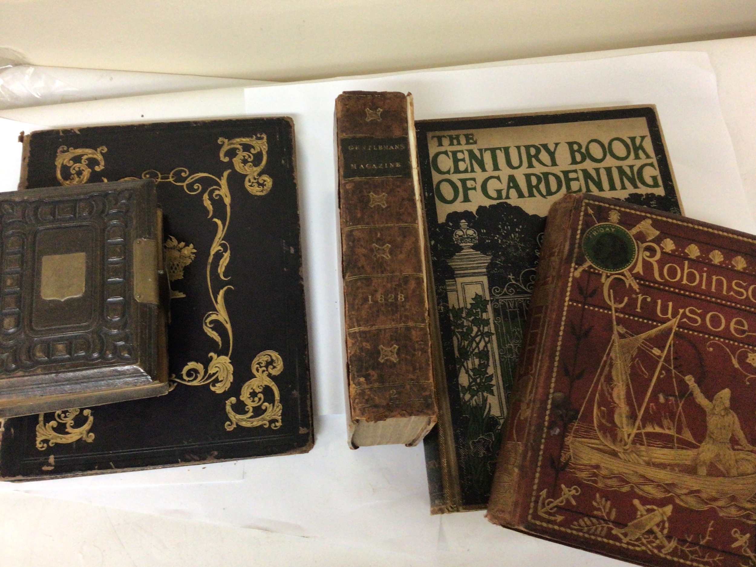 A collection of Antique books including an early edition of Robinson Crusoe by Daniel Defoe over one hundred illustrations landscape History of Scotland Vol II Gentelmans Magazine leather bound from July to December 1828 The Century book of Gardening a Victorian photo album and others.