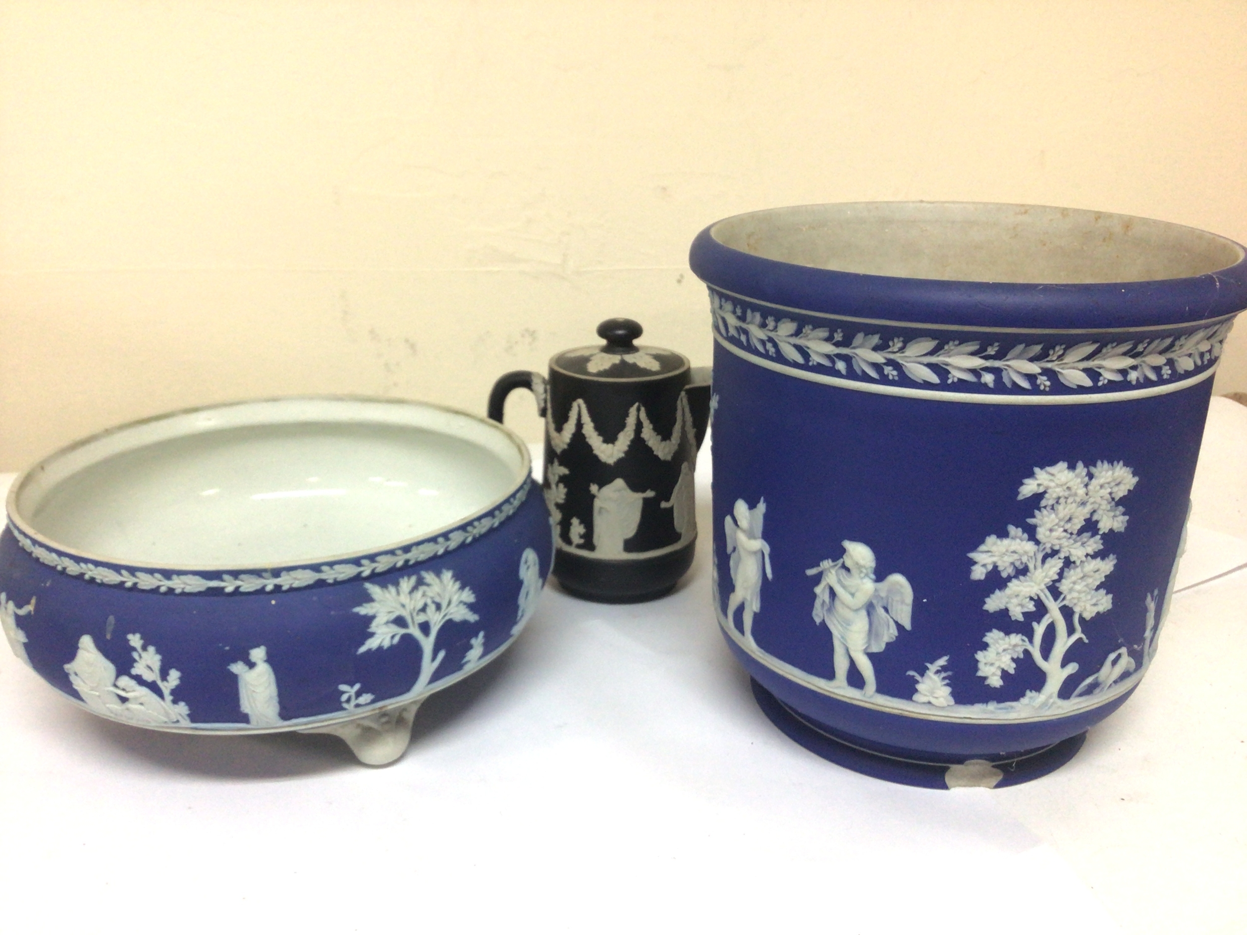  A Wedgwood jasperware bowl decorated with Neo classical figures no damage and a conforming jardiniere with a chip to the rim and a small black jug. (3) 