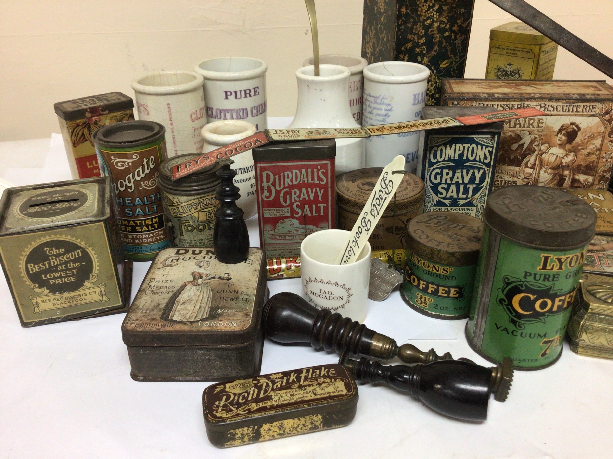  A collection of Vintage and Victorian tins Chocolate tins Gravey Salt Tea Tablets Clotted Cream ceramic jars. a middle eastern 19th century brass scribe set holder and other intresting oddments. 