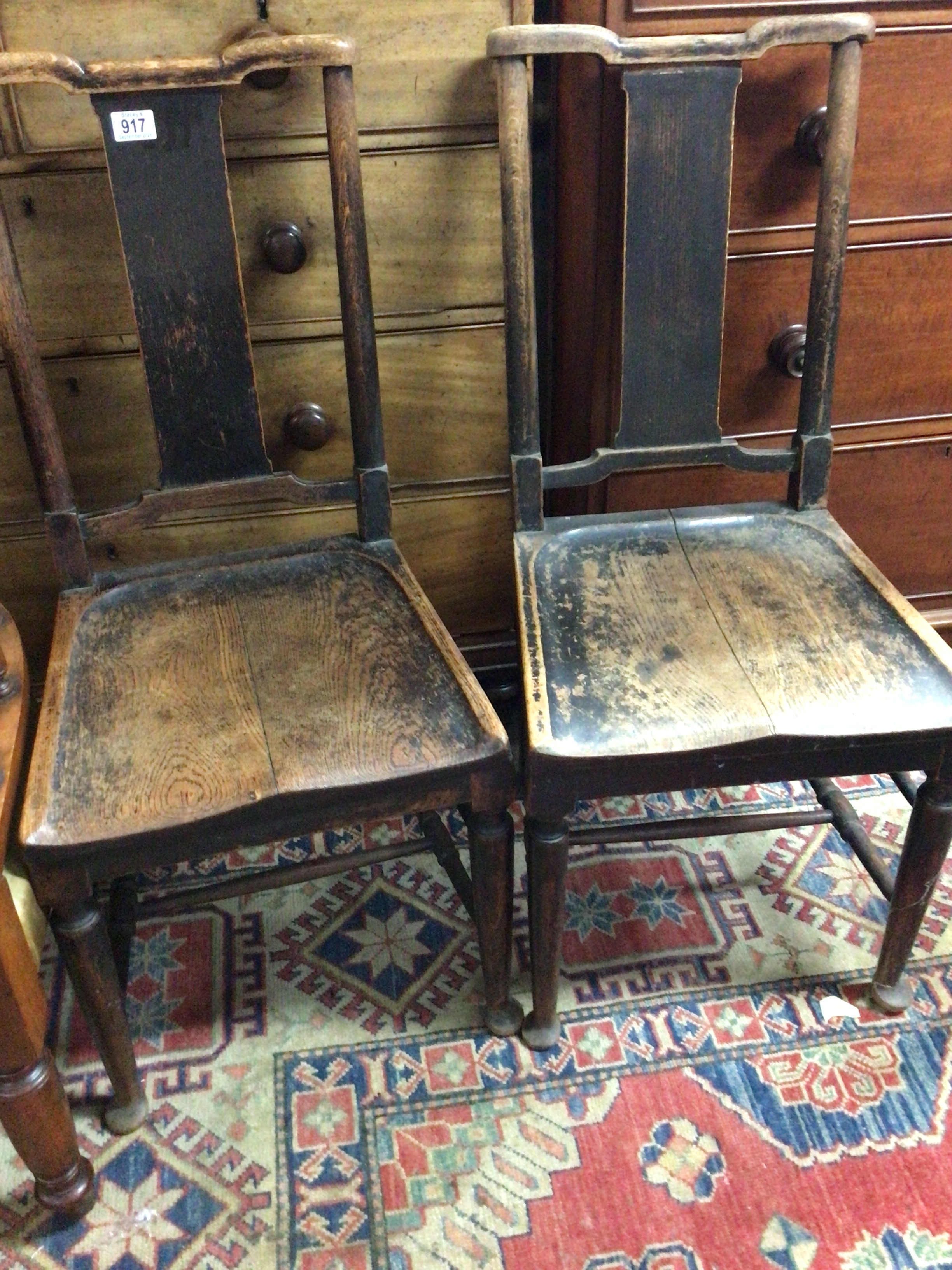  A pair of George III vernacular oak chairs with shaped seats. (2)