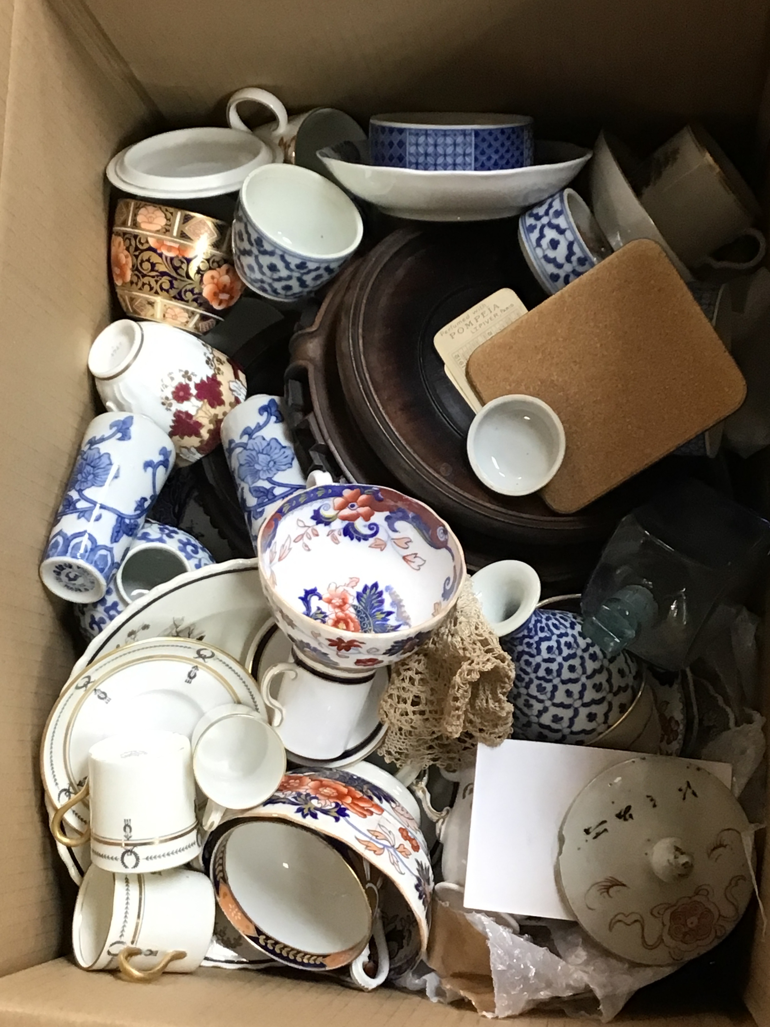 A box containing decorative odd cups and saucers and other oddments 