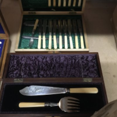 A collection of cased cutlery including silver handle knives and a cased set of spoons .