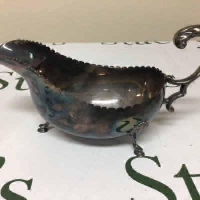 An Irish Silver sauce boat with a shaped edge scroll handle and feet. Dublin hallmarks. Weight 250g