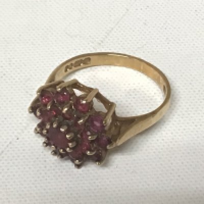 A 9 carat gold ring set with a pattern of red garner stones weight 3.2g approximately.