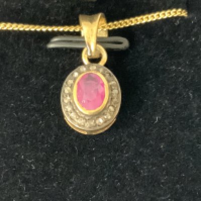 Oval ruby and RBC diamond halo pendant in gold plated silver, boxed. Ruby 0.40ct approx. Diamonds 0.12ct approx. Postage category A.