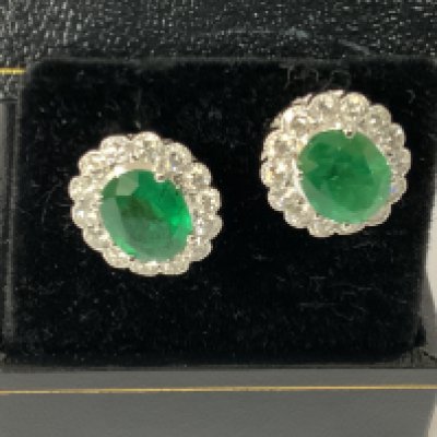 Pair of 18ct white gold stud set with oval emeralds and RBC diamond halos in a scalloped design, boxed. Emeralds 3.23ct. Diamonds 1.26ct. Postage category A
