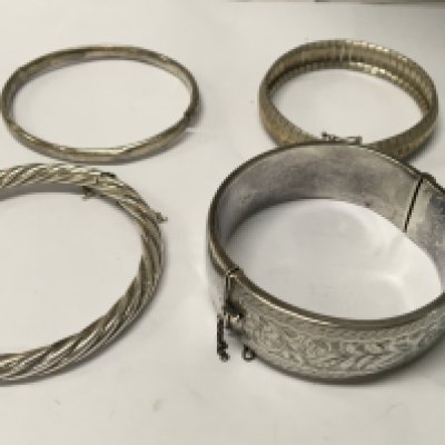 A collection of four silver bangles .