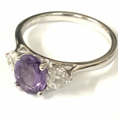 Platinum trilogy ring set with a round purple sapphire flanked by RBC diamonds. Sapphire 1.30ct. Diamonds 0.57ct. Approx ring size L. postage category A.