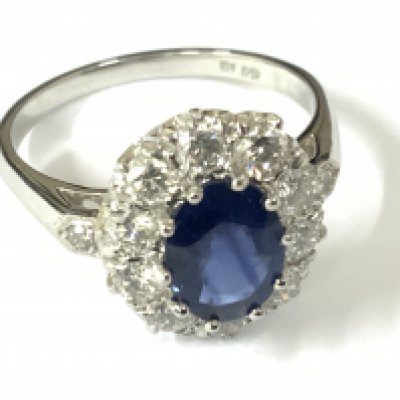 Platinum ring set with an oval sapphire, halo of RBC diamonds and diamond set shoulders. Sapphire 1.50ct approx. Diamonds 0.85ct approx. Approx ring size N. Postage category A