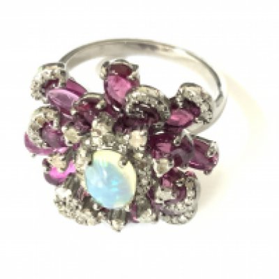 Elaborate silver ring set with an oval cabochon opal, pink tourmalines and diamonds with vintage style box. Opal 0.50ct. Tourmalines 2.65ct approx. Diamonds 0.40ct. Approx ring size N/O. Postage category A