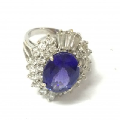 A white gold large oval Tanzanite and diamond ring. Tanzanite carat weight 4.50ct set with 26 round diamonds and 6 tapper baguettes weighing 1.10ct Size N with gemologists report