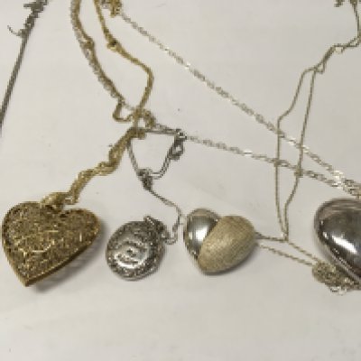 A collection of five silver pendant on chains .