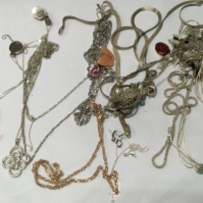 A collection of various silver chains and necklaces .