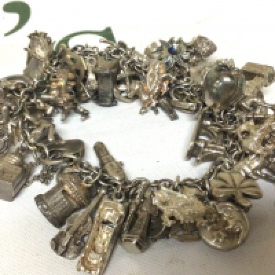 A silver charm bracelet with numerous charms. Weight 137g approximately.