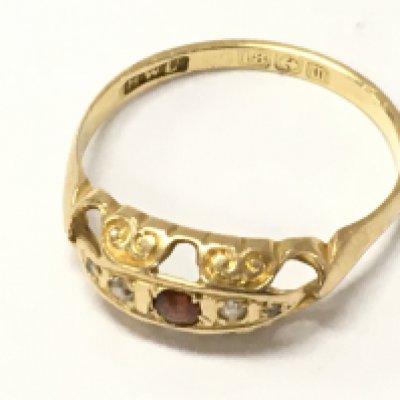 An 18ct gold ring set with ruby and small diamond chips , size O. 1.9g total weight.Postage category A