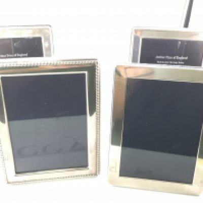 Four silver hallmarked photo frames. Approximately 12x16cm