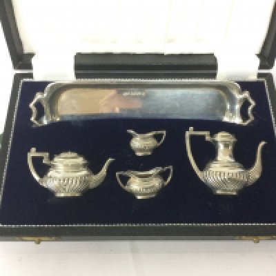 A cased silver miniature tea and coffee service and a cased silver plated set (2). Shipping category B.