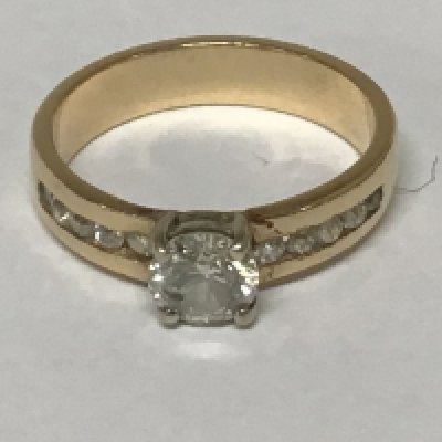 A gold ring set with a a half carat diamond the shank with a further row of small brilliant cut diamonds. Total weight 4.5g ring size P.
