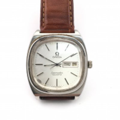 A vintage Omega Seamaster quartz watch with silver dial and brown leather strap. Case approximately 36mm. Not seen running. Postage B