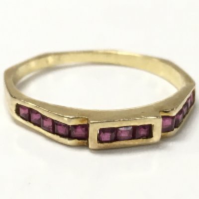 A gold ring set with a row of rubies, unmarked. Size L. 1.6g. Postage category A