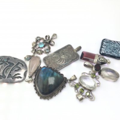 A collection of 9 silver pendants. Postage B