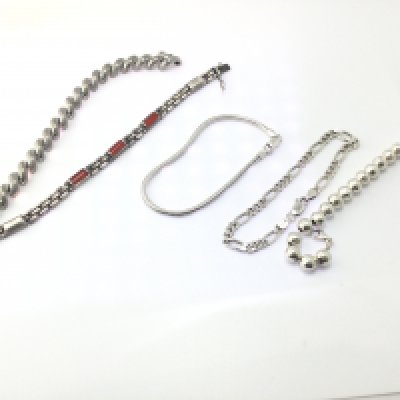 A collection of 5 silver bracelets of various designs.