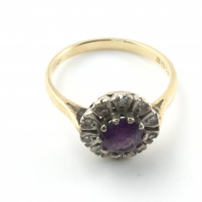 An 18ct gold ring set with amethyst and white stones. Size O 1/2 and 3.92g Postage A