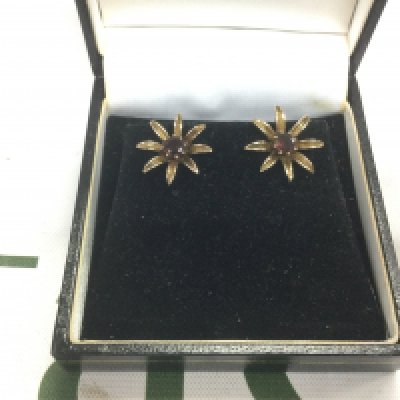 A pair of. 9ct gold earrings in the form of flowerheads and set with garnets. Shipping category A.