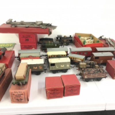 A collection of clockwork tinplate railway locos with numerous wagons and coaches plus some track and accompanied. 0 gauge. No reserve (2)