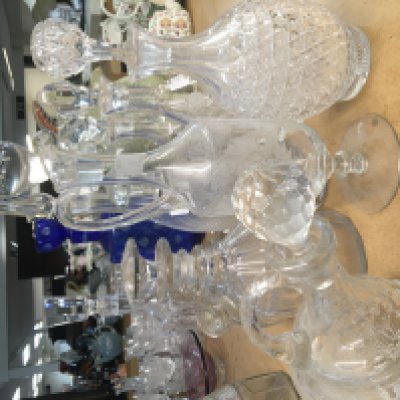 A collection of glass decanters including a modern design blue glass decanter a late George III decanter with mushroom stopper and ring neck and many other decanters. (a lot)