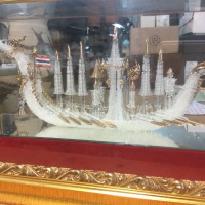 A glass ornament in the form ceremonial boat in der a glass case . 30 x18 cm .