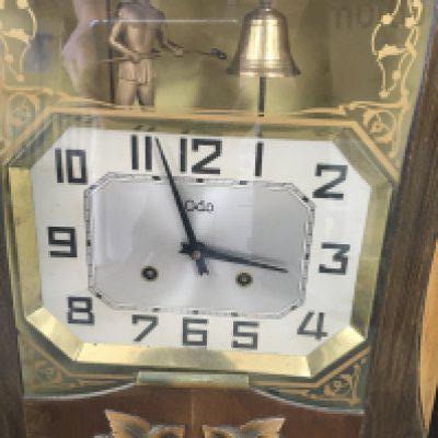 A wall clock the dial with Arabic numerals above a classical figure striking A bell . 45 x35 cm .