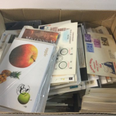 A box with a first day covers album and other spare and loose stamps and first day covers.