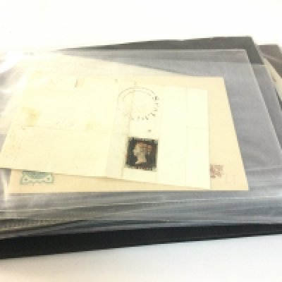 A stamp album of Victorian covers including a black penny stamp and other various stamps from the 1800s.