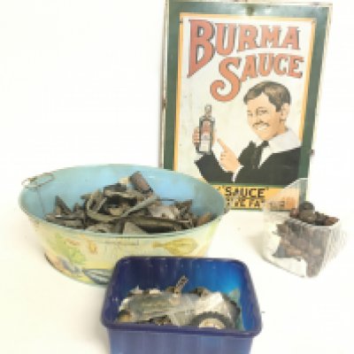 A collection of metal detector finds, a vintage enamel Burma Sauce advertisement, leather buttons and military cap badges. NO RESERVE
