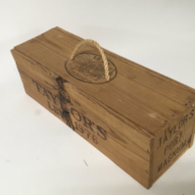 A 1976 Vintage bottle of Taylor&rsquo;s Port Magnum sealed and unopened in a wooden casket.