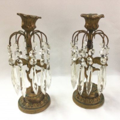 A pair of gilt metal candle holders with glass drops.- NO RESERVE