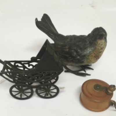 An Austrian cold painted bronze figure of a bird. A miniature tape measure and pram (3)