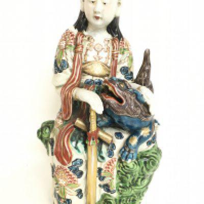 A 19th Century Kakiemon Japanese figure group of a lady and a temple lion, 32cm tall. Some hairline cracks. Cannot be posted