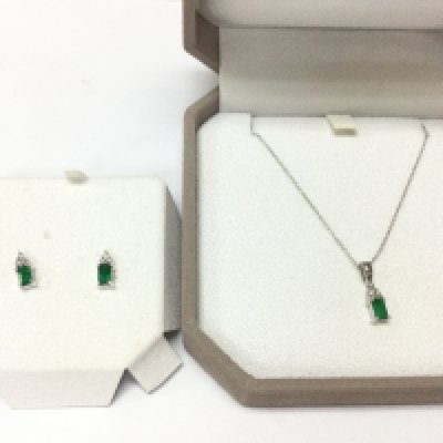 An 14ct white gold emerald and diamond pendant and chain with a matching pair of stud earrings. Postage B