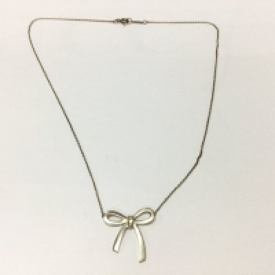 A boxed silver Tiffany and Co bow necklace.