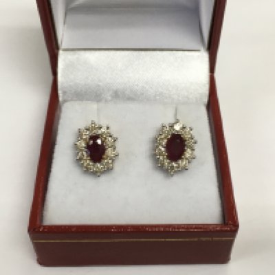 A pair of 9ct yellow and white gold oval ruby and RBC diamond cluster studs. Rubies approx 1.43ct and diamonds approx 1.00ct. Approx 3.6g. Shipping category A.
