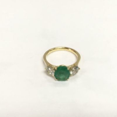 An 18ct yellow gold trilogy ring set with an oval emerald flanked by RBC diamonds. Emerald approx 1.72ct, diamonds approx 1.23. Approx 3.8g and approx size M-N. Shipping category A.