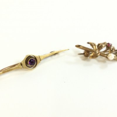 Two brooches, one 9ct gold ruby and pearl set and the other marked 15c set with a purple amethyst. Total weight 4.2g .Postage category A