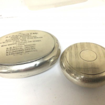 Two silver tobacco boxes one of round shape with engine turned decoration the other with the inscriptions RT Richmond Esq House Surgeon. 1902 (2)