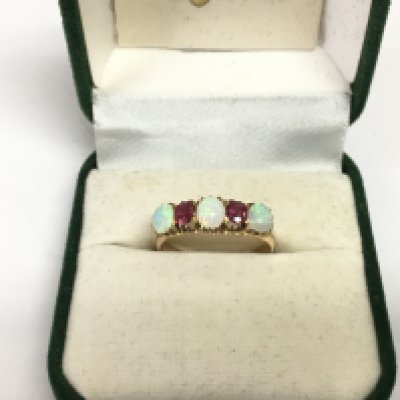 A 15ct gold ring set with opals and rubies, approx 2.8g and approx size N. Shipping category A.