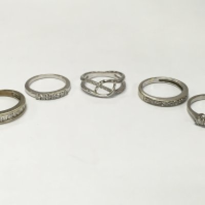 A Collection of high carat unmarked white gold white stone set rings (10g total weight) and a silver ring. Sizes I, M. 12.8g total weight. Postage cat a