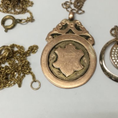 A 9 ct gold pendant (4.5grams ) two gold tone chains and a silver chain and pendant.