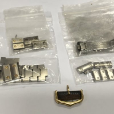 A small collection of spare watch links, an 18ct gold Cartier buckle etc. Shipping category A.