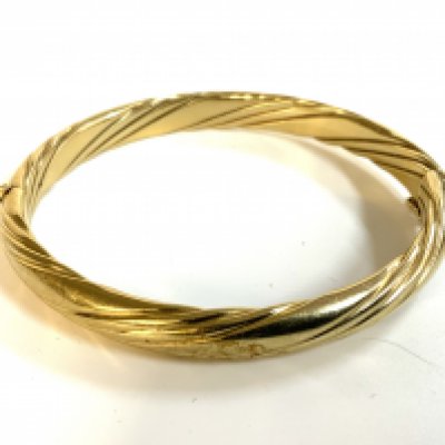 A 9ct gold twist design bangle, metal core. total weight 23.5g.